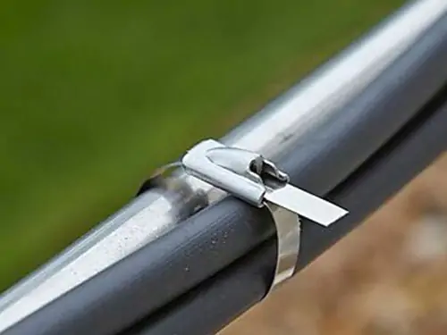 Epoxy coated stainless steel cable ties securing industrial metal pipes, corrosion resistant self-locking metal zip ties for outdoor wiring fastening
